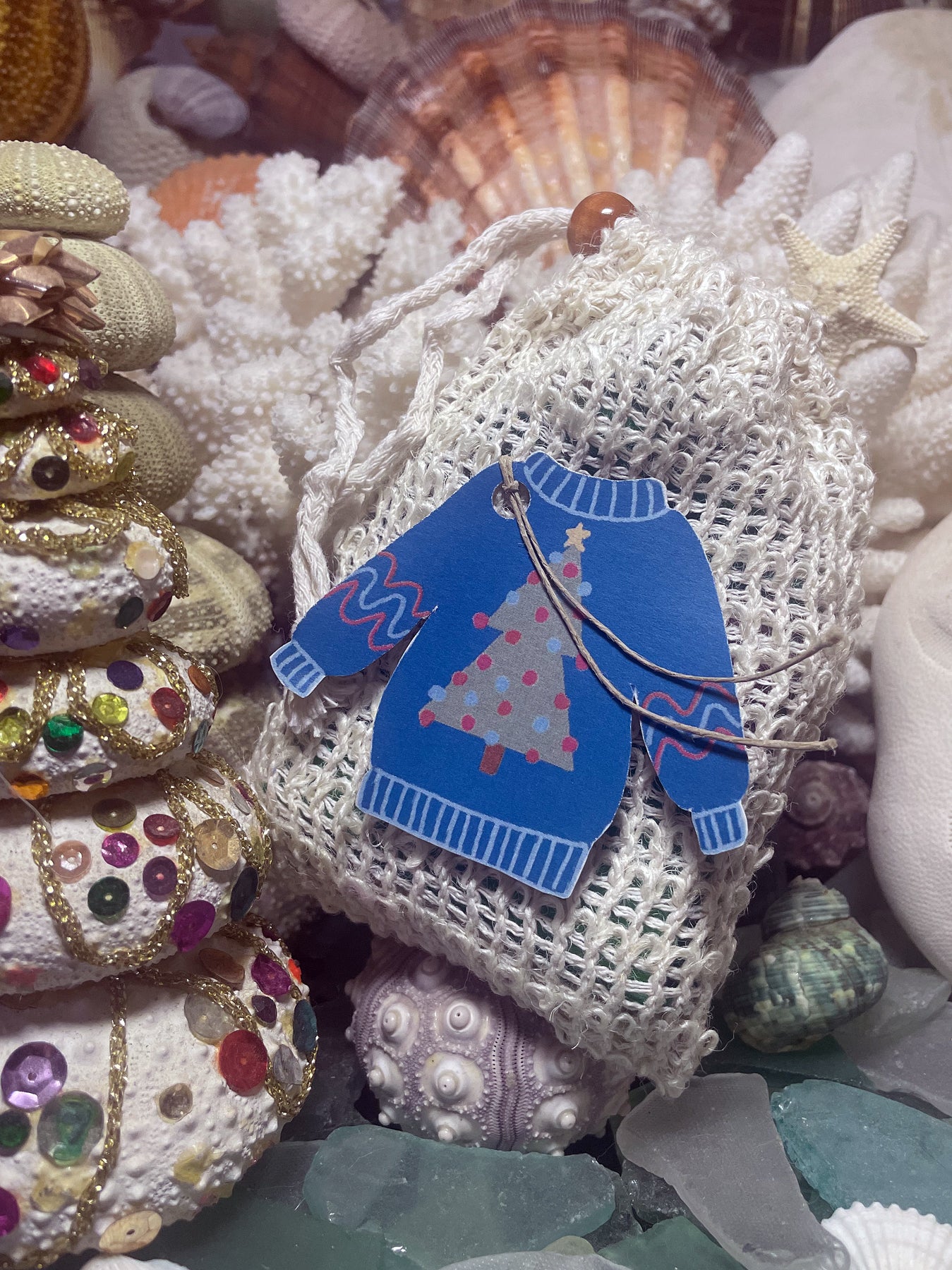 Ugly Sweater holiday soap in a mesh gift bag with a blue Christmas sweater tag.