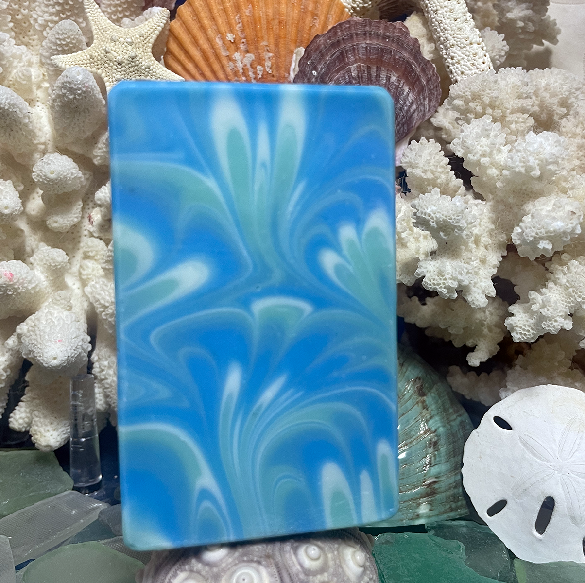 Handcrafted Seaside Melody bar soap with ocean-inspired swirls of bright blue, seafoam green, and white, creating a smooth coastal wave design