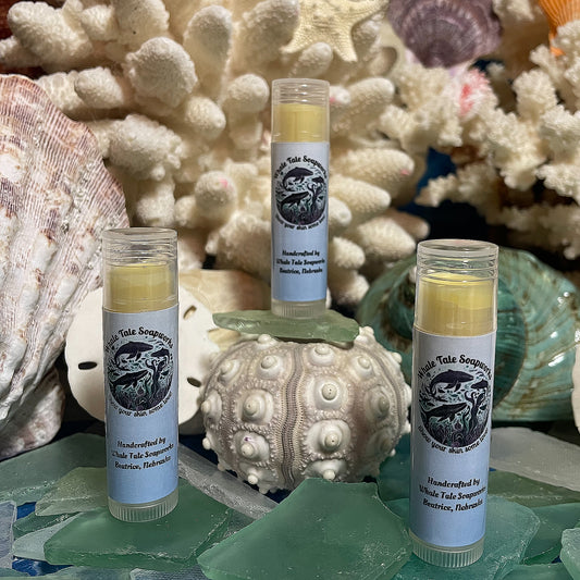 Three tubes of Whale Tale Soapworks Sun Kissed Lip Balm. Handcrafted in Beatrice, Nebraska, this all-natural lip balm is made with shea butter, coconut oil, beeswax, and olive oil for soft, hydrated lips with a sun-kissed glow.
