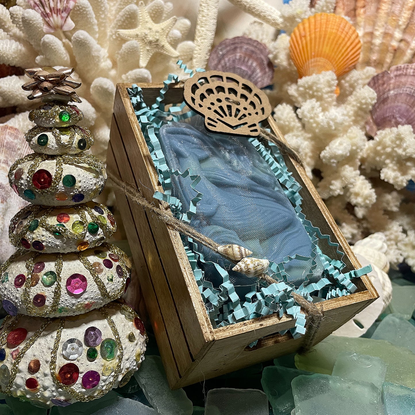 Whale Tale Signature Bar gift box with a blue swirled handmade soap in an organza bag, nestled in a wooden box with teal crinkle paper.